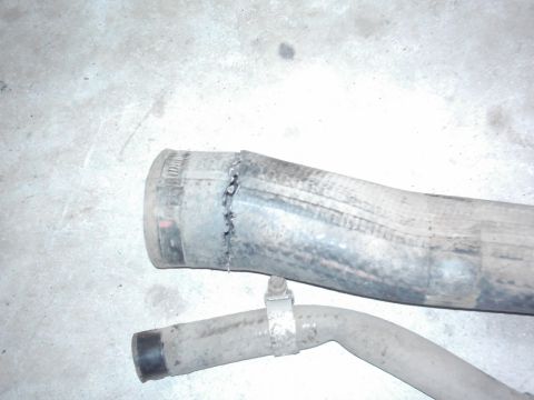 1978 Ford Bronco - Close-up of a damaged exhaust pipe, showing a clamp and a crudely cut end.