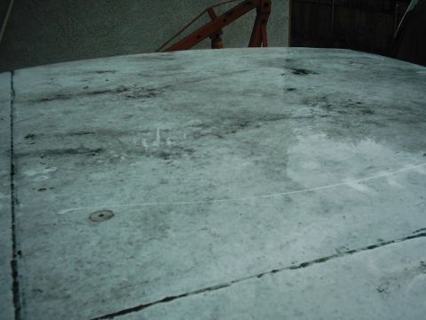 1978 Ford Bronco - The top of a vehicle shows water stains and a seam, with a piece of orange equipment visible in the background.