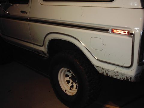 1978 Ford Bronco - Close-up of the rear quarter panel and wheel of a white SUV.