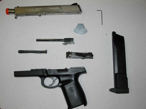 1996 Ford Taurus - The components of a handgun are laid out on a flat surface for cleaning or repair.