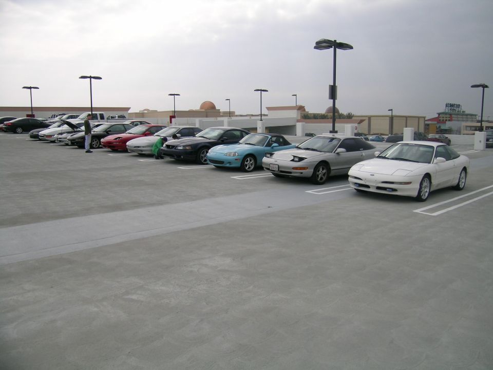 Several 1993 Ford Probes parked in a lot, one white, one silver, and others further back