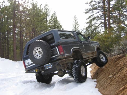 1985 Ford Bronco - This Ford Bronco is navigating a challenging snowy and muddy terrain.