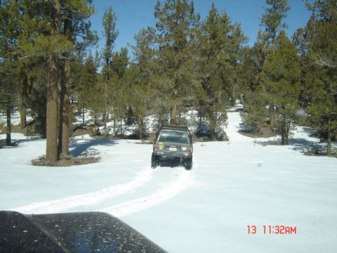 2000 Ford F-450 - SUV driving through snow with tire tracks visible on the road.