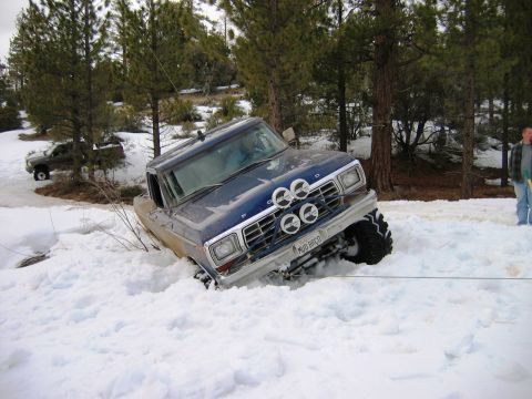 1985 Ford Bronco - Ford Bronco stuck in snow, with another vehicle visible in the background.
