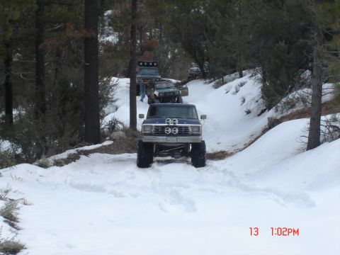 2000 Ford F-450 - A convoy of off-road vehicles navigates a snowy mountain trail.