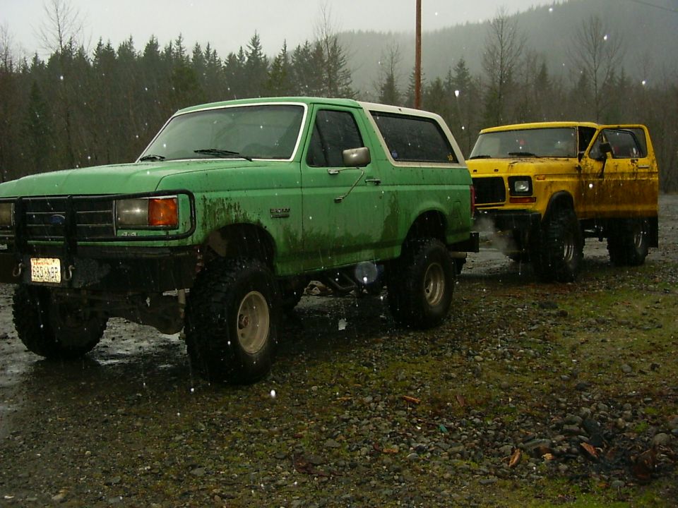 Green Ford Bronco with lifted suspension and off-road tires parked on a gravel lot