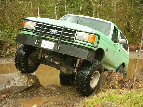 1990 Ford Bronco - This modified Ford Bronco is tackling a challenging off-road course.