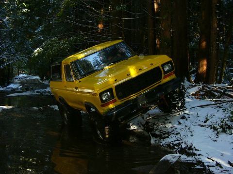 1990 Ford Bronco - Yellow 1978 Ford Bronco navigates a snowy, watery forest trail.