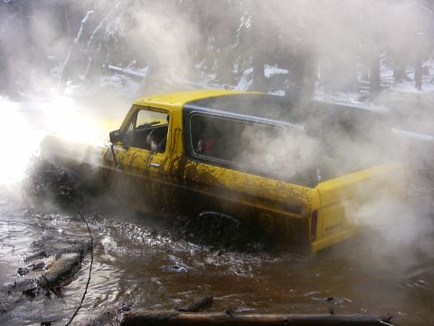 1990 Ford Bronco - This yellow Ford Bronco is navigating through a muddy, watery obstacle course.
