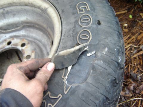 1992 Ford Bronco - A hand is shown holding a torn piece of a Goodyear tire, revealing significant damage to the tread.