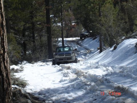 2000 Ford F-450 - A Ford F-Series truck navigates a snowy mountain road with another vehicle visible in the distance.