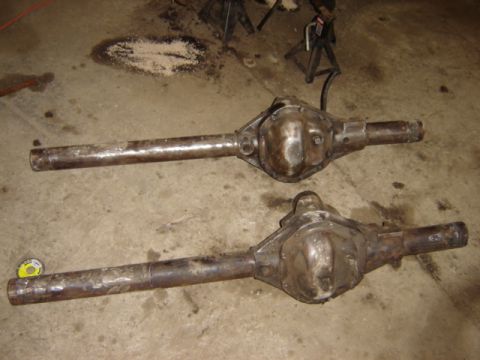 1992 Ford Bronco - Two differential axles are shown on a concrete floor, possibly for repair or replacement.