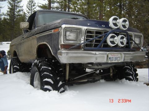 2000 Ford F-450 - This lifted pickup truck, likely from the late 1970s, is equipped with oversized tires and auxiliary lights, seen here in a snowy environme…