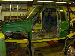 1990 Ford Bronco - A worker in a yellow hard hat examines a green vehicle body during its assembly process.