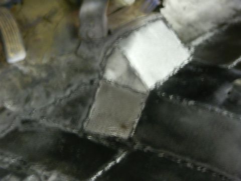 1990 Ford Bronco - The floor of a vehicle, showing textured mats and pedals, with a watermark for Supermotors.net.