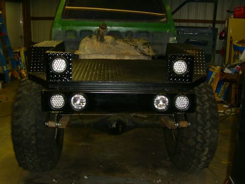 1990 Ford Bronco - Rear view of a modified truck bed with custom lighting and large off-road tires.