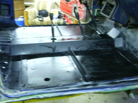 1990 Ford Bronco - The interior floor pan of a vehicle, showing two gear shifters and a blacked-out central console area.