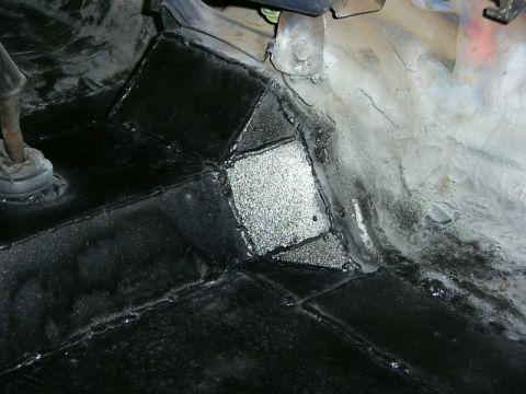 1990 Ford Bronco - Underbody rust repair with sealant applied to patched metal sections.