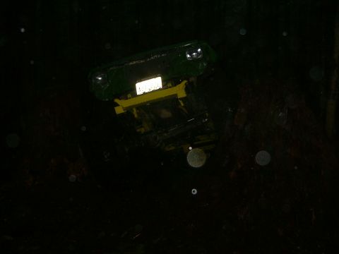 1990 Ford Bronco - A green tractor with a yellow front loader is shown in the dark.