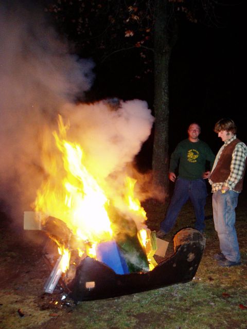 1995 Ford Bronco - Two people stand by a large bonfire at night, with smoke billowing into the air.