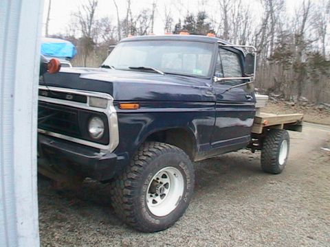 1977 Ford F-250 - This 1977 Ford F-250 pickup truck is shown from the front quarter angle with a flat wooden bed.