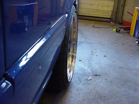 1998 Volkswagen Jetta - Side view of a blue car's body and chrome wheel, with the Supermotors.net logo in the corner.