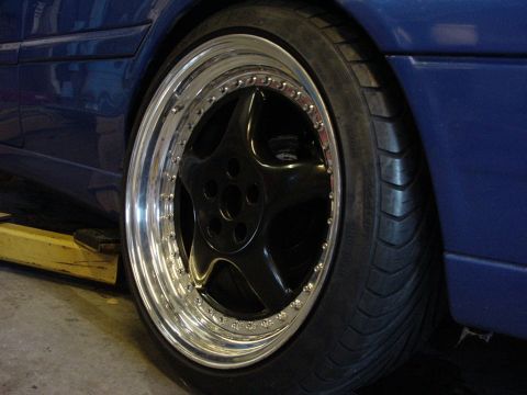 1998 Volkswagen Jetta - A close-up view of a custom wheel and tire on a blue vehicle, possibly undergoing maintenance.