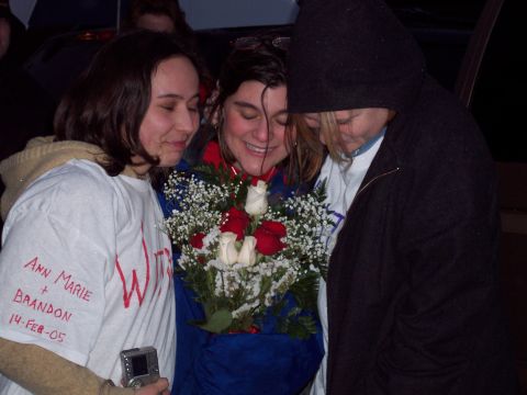 1987 Ford Bronco - Three people share a moment of joy, with one holding a bouquet of roses and another wearing a shirt with wedding details.
