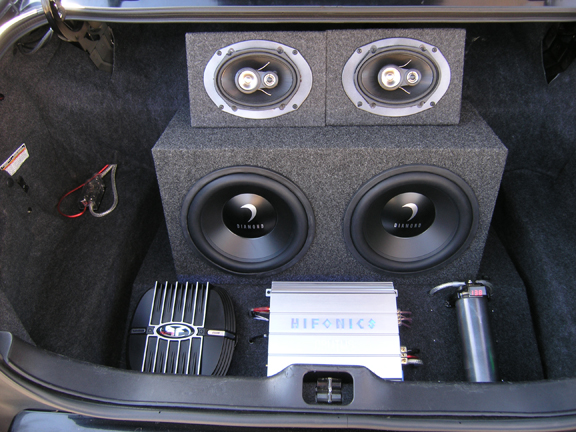 Trunk audio install: two Diamond subwoofers, 6x9 speakers, Hifonics amp, and capacitor in carpeted trunk