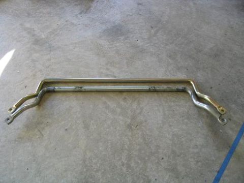 1999 Ford Crown Victoria - Two metal bars, likely automotive parts, lie on a concrete surface.