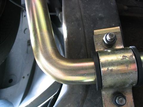 1999 Ford Crown Victoria - Close-up view of a vehicle's suspension system, showing a metal bar and mounting hardware.