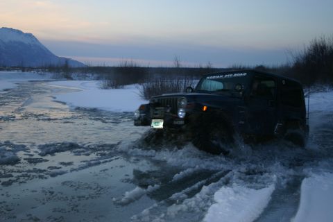 2003 Jeep TJ - A dark blue 2003 Jeep TJ navigates through icy water, with a 'KODIAK OFF-ROAD' sticker visible on the windshield.