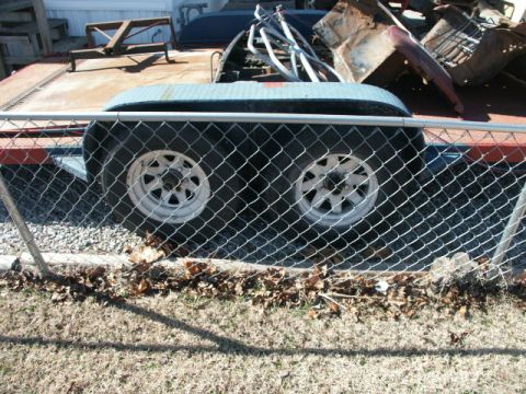 1995 Ford Bronco - A trailer loaded with scrap metal is viewed through a chain-link fence.