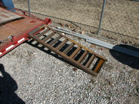 1995 Ford Bronco - A metal ramp rests on the bed of a red trailer.