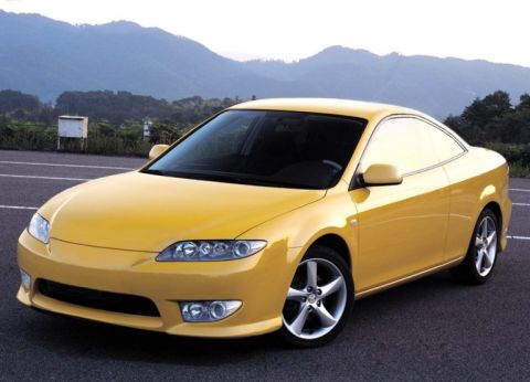 1997 Ford Probe - This yellow coupe features unique headlights and stylish five-spoke wheels, captured in a three-quarter front view.