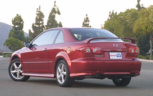 Red Mazda 6 coupe with a spoiler, parked outdoors. License plate reads 'edmunds.com'