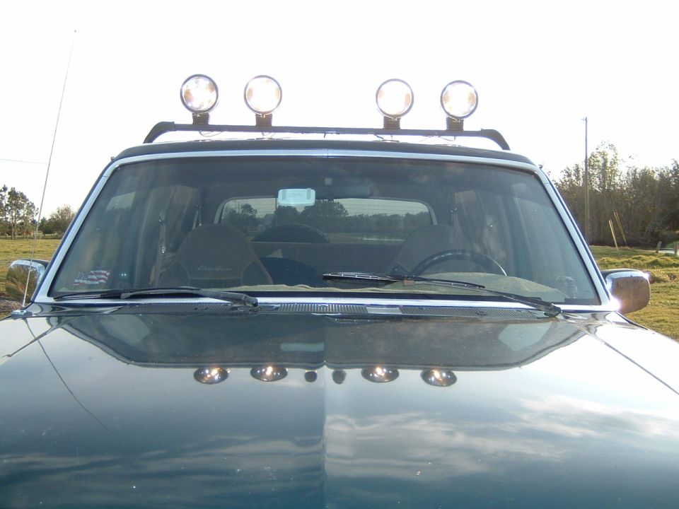 Dark green SUV front view with roof rack lights