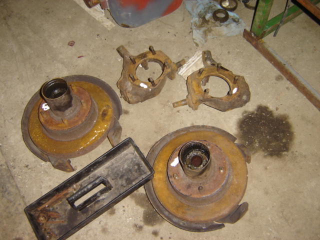Rusty brake rotors and steering knuckles on a concrete floor