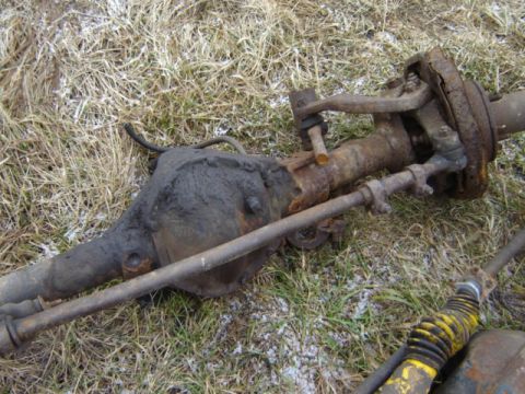 1992 Ford Bronco - This is a front axle assembly, likely from a Ford Bronco, lying on the ground.