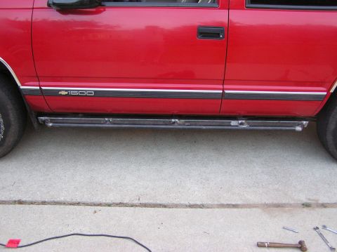 2000 Chevrolet Tahoe - Side view of a red truck with custom running boards and a "1600" badge.