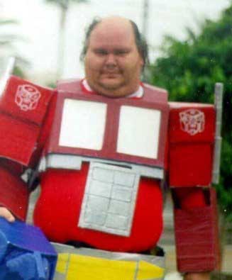 1990 Ford Bronco - A person is dressed in a DIY Optimus Prime costume, complete with the iconic red and blue color scheme and Autobot insignia.