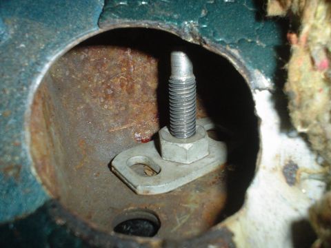 1993 Ford Taurus - This image shows a close-up of a rusted metal bracket with a bolt and nut, likely a part of a vehicle's interior or undercarriage.
