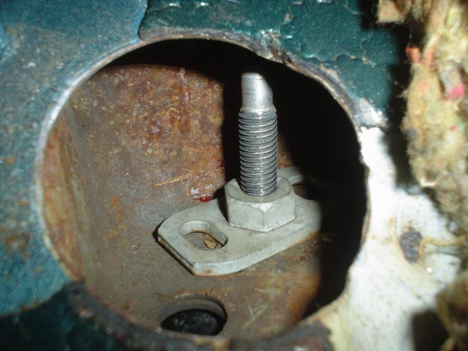 Close-up of a rusted metal bracket with a bolt and nut, showing signs of wear and tear