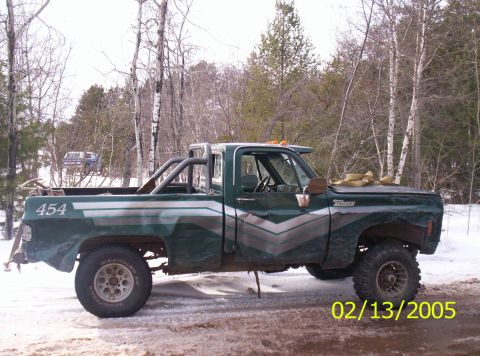 1978 Chevrolet C/K Pickup - A lifted green pickup truck with a roll bar and custom graphics sits in a snowy, wooded area.