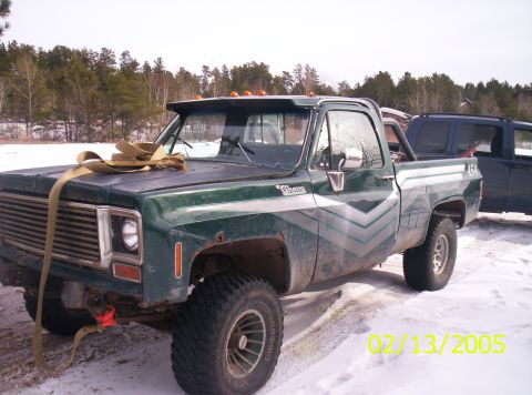 1978 Chevrolet C/K Pickup - This green 1978 Chevrolet C/K Pickup, adorned with a large bow, sits in a snowy landscape next to another vehicle.