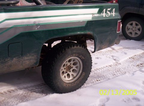 1978 Chevrolet C/K Pickup - Rear view of a green 1978 Chevrolet C/K Pickup with "454" on the fender, parked in snow.