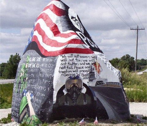 1991 Ford Bronco - A large rock painted with patriotic imagery, including an American flag, a pilot's helmet, and a quote attributed to George W. Bush from 20…