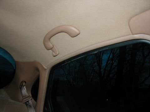 1997 Ford Taurus - Interior view of a grab handle and window in a 1997 Ford Taurus.