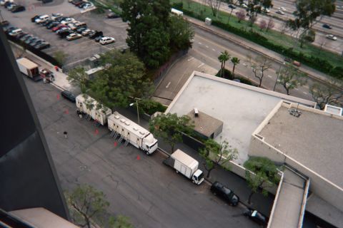 1990 Ford Bronco - High-angle view of a parking area with a long white tractor-trailer and a small box truck parked along a building beside multi-level lots.