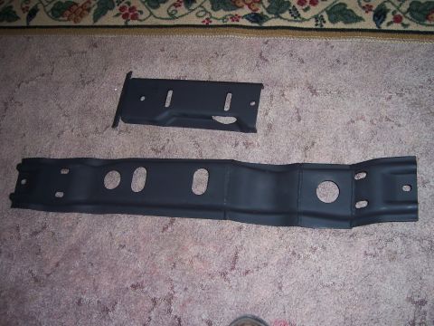 1983 Ford Bronco - Two black metal brackets are shown on a carpeted surface.